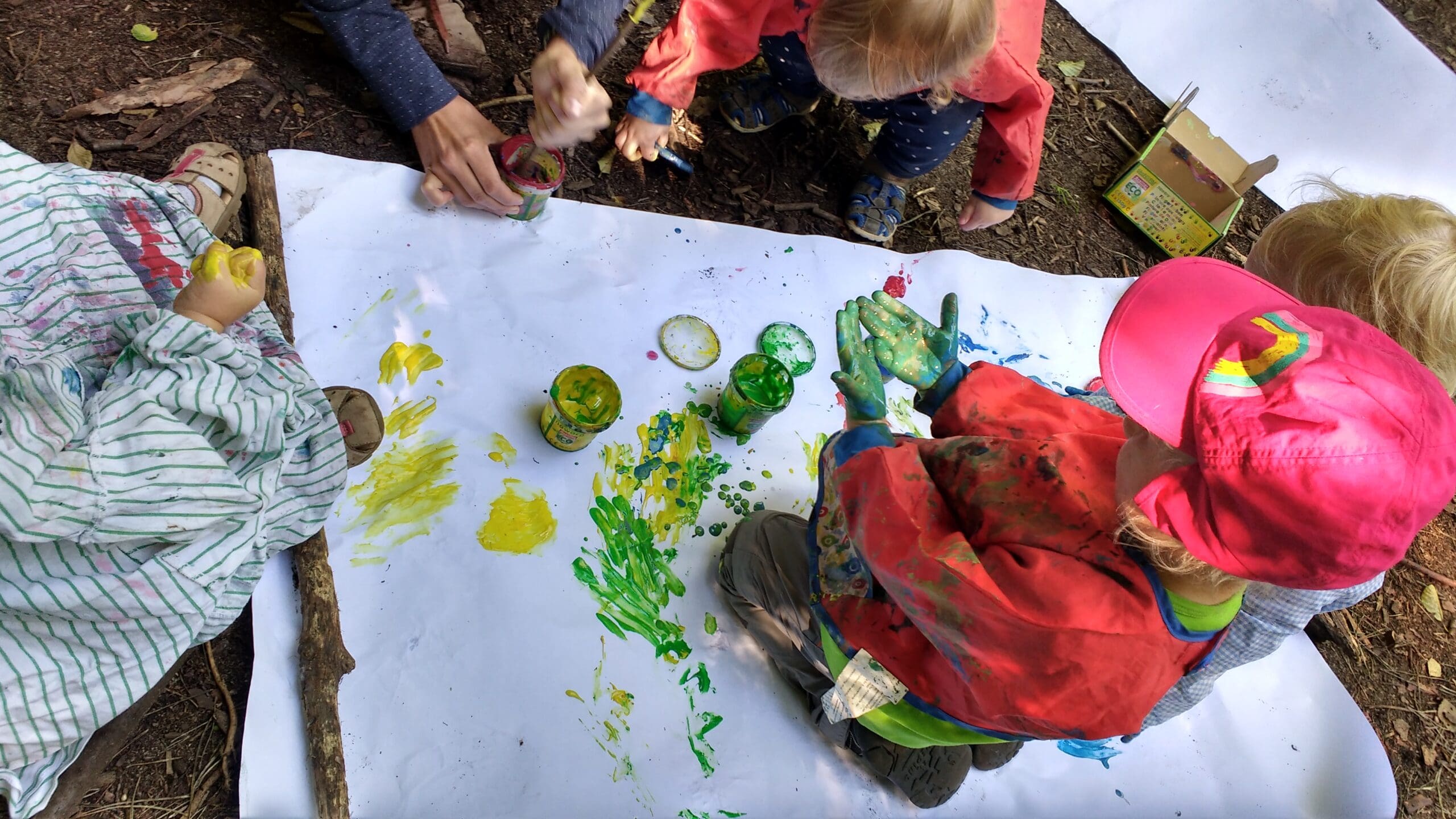 Eine Gruppe von Kindern malt mit ihren Händen